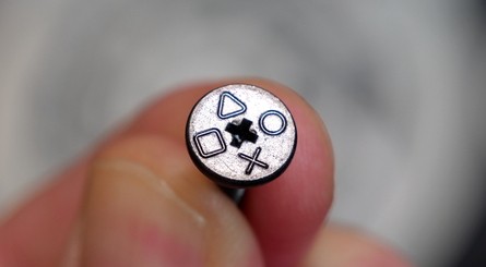 (Clockwise from top left) The SSD slot is located in the bottom-left corner of the console, as shown in this photo. Use a crosshead screwdriver to remove the screw, and note the fancy PlayStation symbols. Lift the metal plate away to reveal the SSD slot beneath.