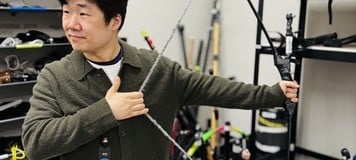 A Pearl Abyss employee demonstrates a bow prop in the studio's motion capture studio