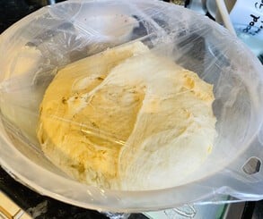 The dough's first proving saw it grow a lot! Once rolled out, I scattered the cinnamon filling and rolled it up, cut it into pieces, and put the rolls down onto the caramel-like topping.