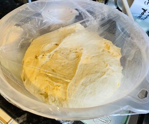 The dough's first proving saw it grow a lot! Once rolled out, I scattered the cinnamon filling and rolled it up, cut it into pieces, and put the rolls down onto the caramel-like topping.