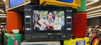 A tower of televisions showing a NewJeans music video